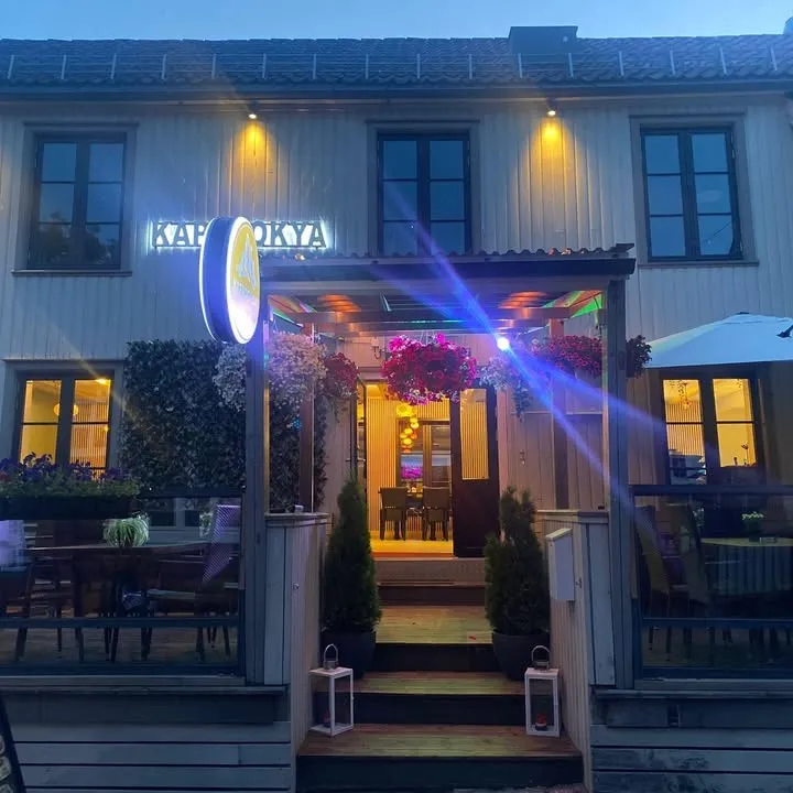 Kapadokya i Nedre Langgate en kveld: det hvite trehuset med opplyst skilt, blomsterkasser og terrasse